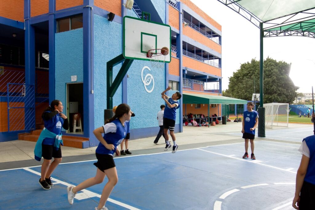 Alumnos jugando basquetbol