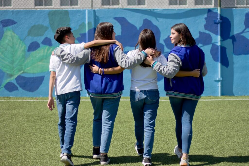 Alumnos de secundaria abrazados en la cancha del Colegio
